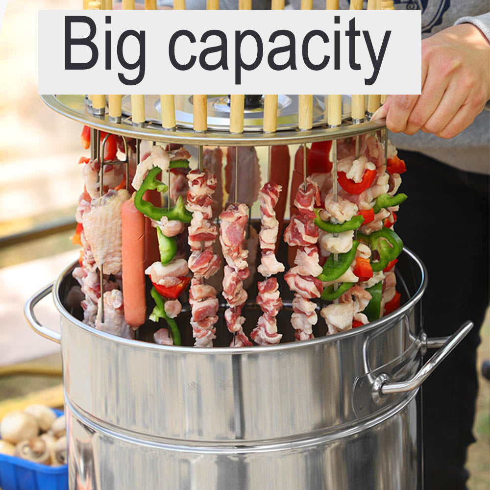A person lifting a skewer rack filled with many meat and vegetable kebabs from a large stainless steel barrel grill.